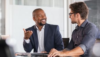 Two happy business colleagues at meeting in modern office interior.