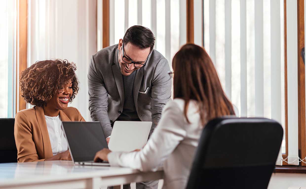 two women and a man working at a desk